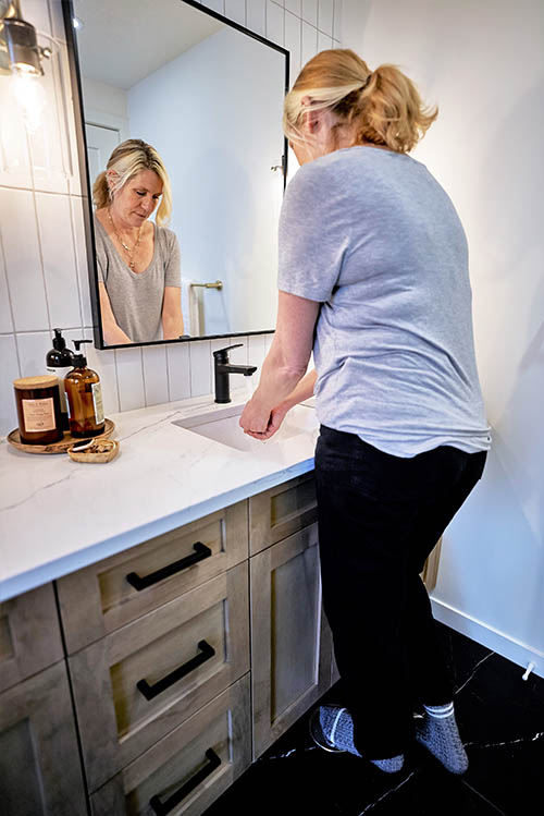 washroom_in_use woman using Tapmaster in bathroom